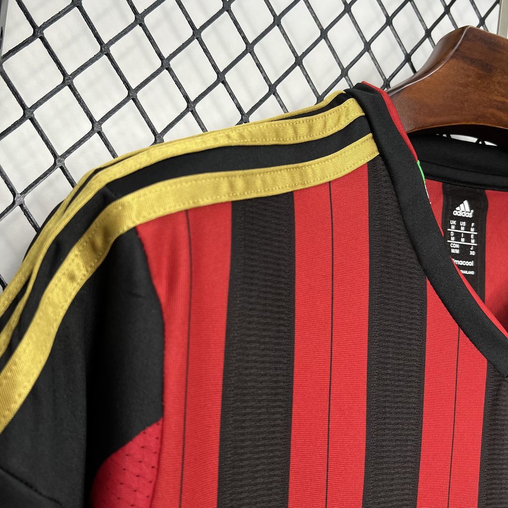 AC Milan home soccer jersey collar detail with yellow trim and red-and-black vertical stripes