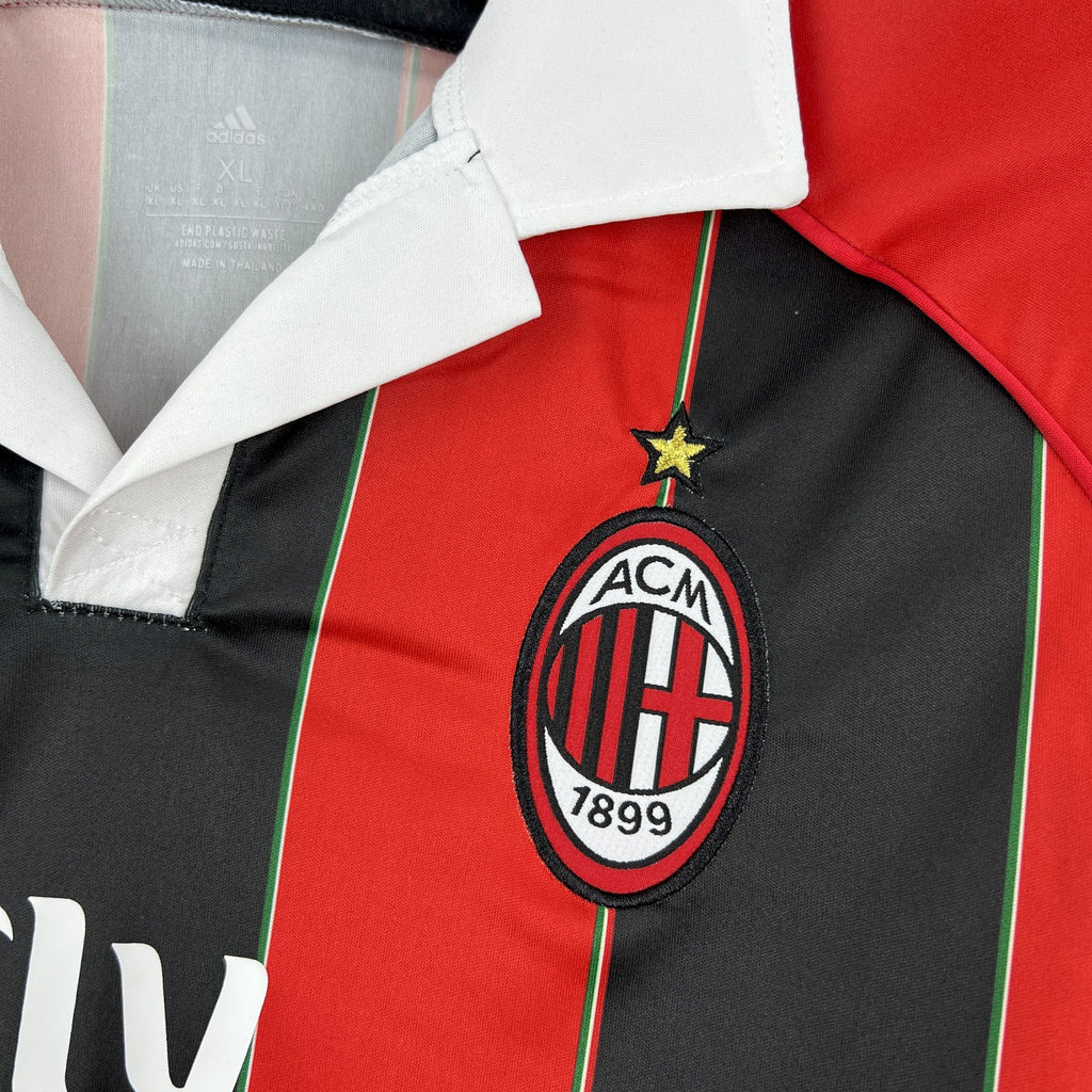 AC Milan crest emblem on red and black soccer jersey with white collar