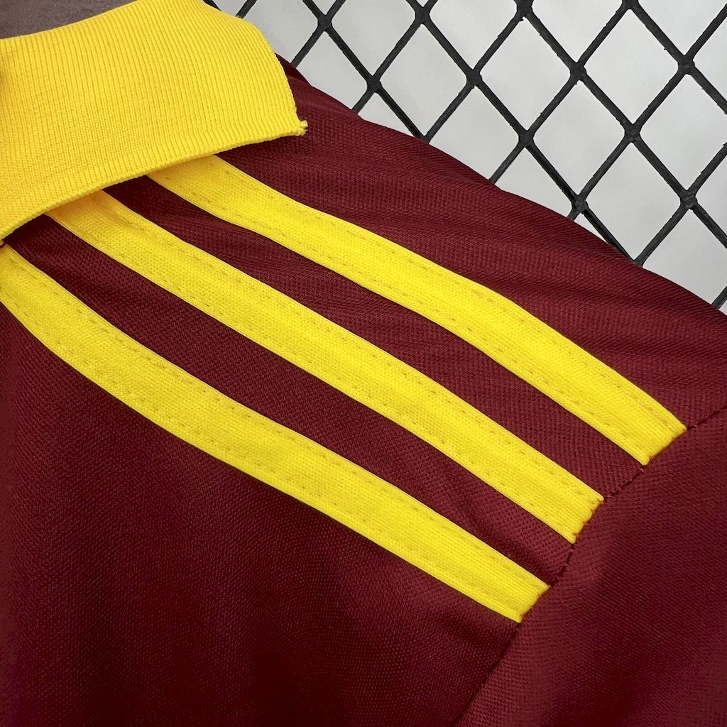 Maroon jersey sleeve with bold yellow shoulder stripes