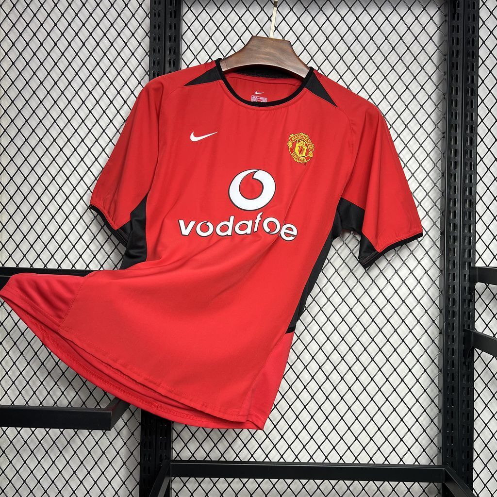 Red Manchester United home football shirt with crest and Vodafone sponsor, front view angled