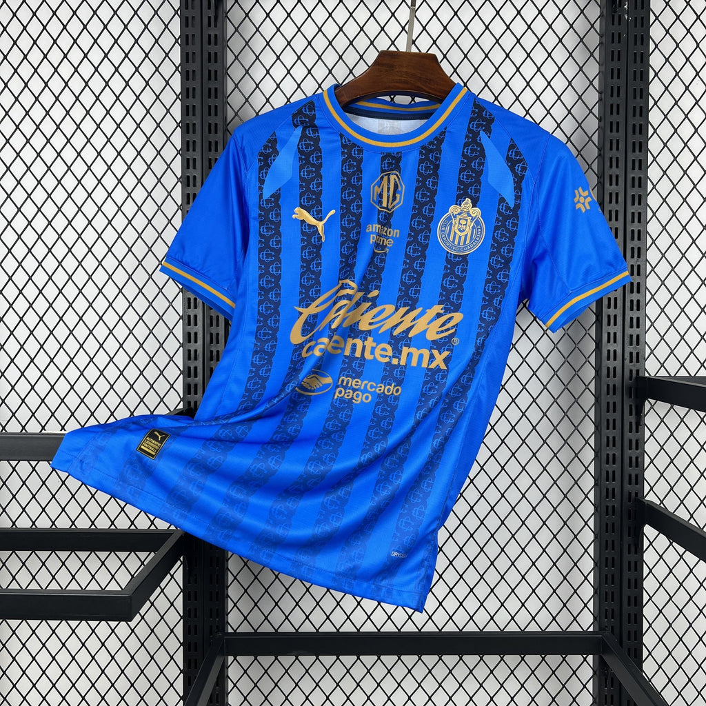 Blue soccer jersey with vertical stripes, crest, and gold sponsor text; folded on rack
