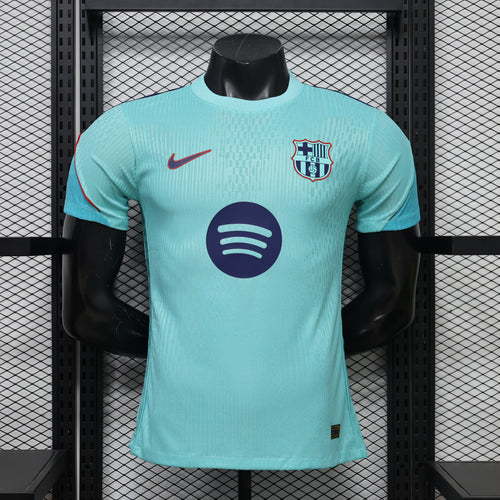 Turquoise training top with Nike swoosh, FC Barcelona crest, and circular emblem