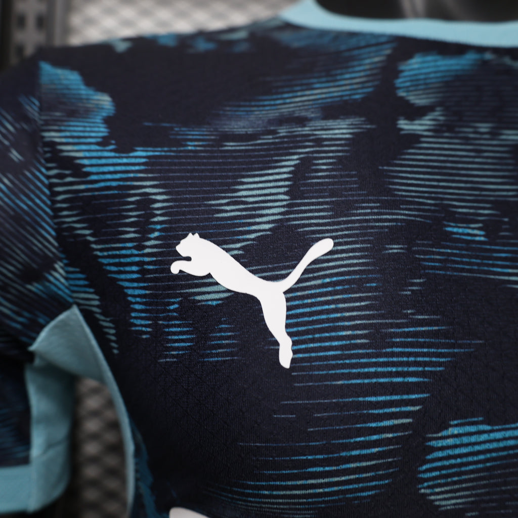 Dark navy soccer jersey with blue camo pattern and white Puma logo on chest.