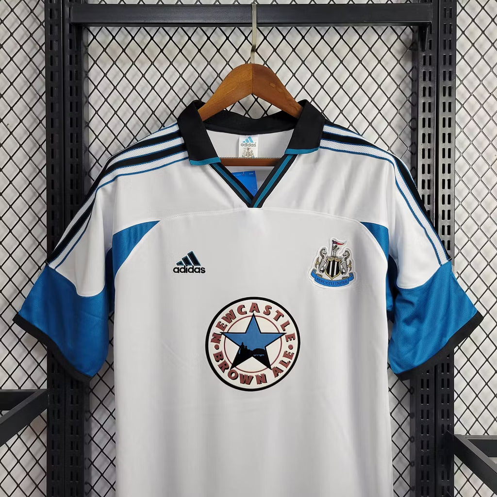 White retro football jersey with Newcastle crest, adidas badge, and blue shoulder stripes