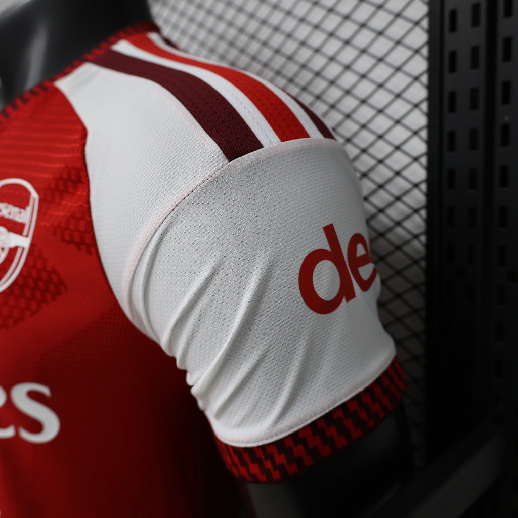 Arsenal home football jersey sleeve close-up, white cuff with red adidas logo and trim