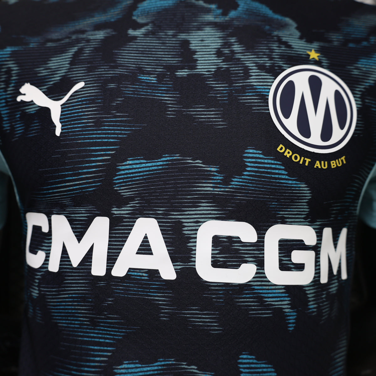 Navy jersey chest close-up with Puma logo, Marseille crest, and CMA CGM