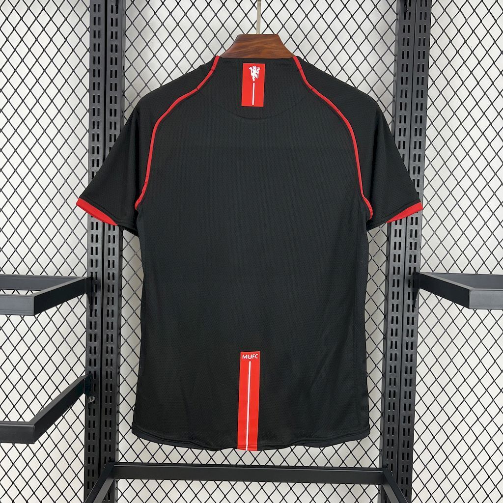 Retro away football jersey back view, black with red side stripe and MUFC label