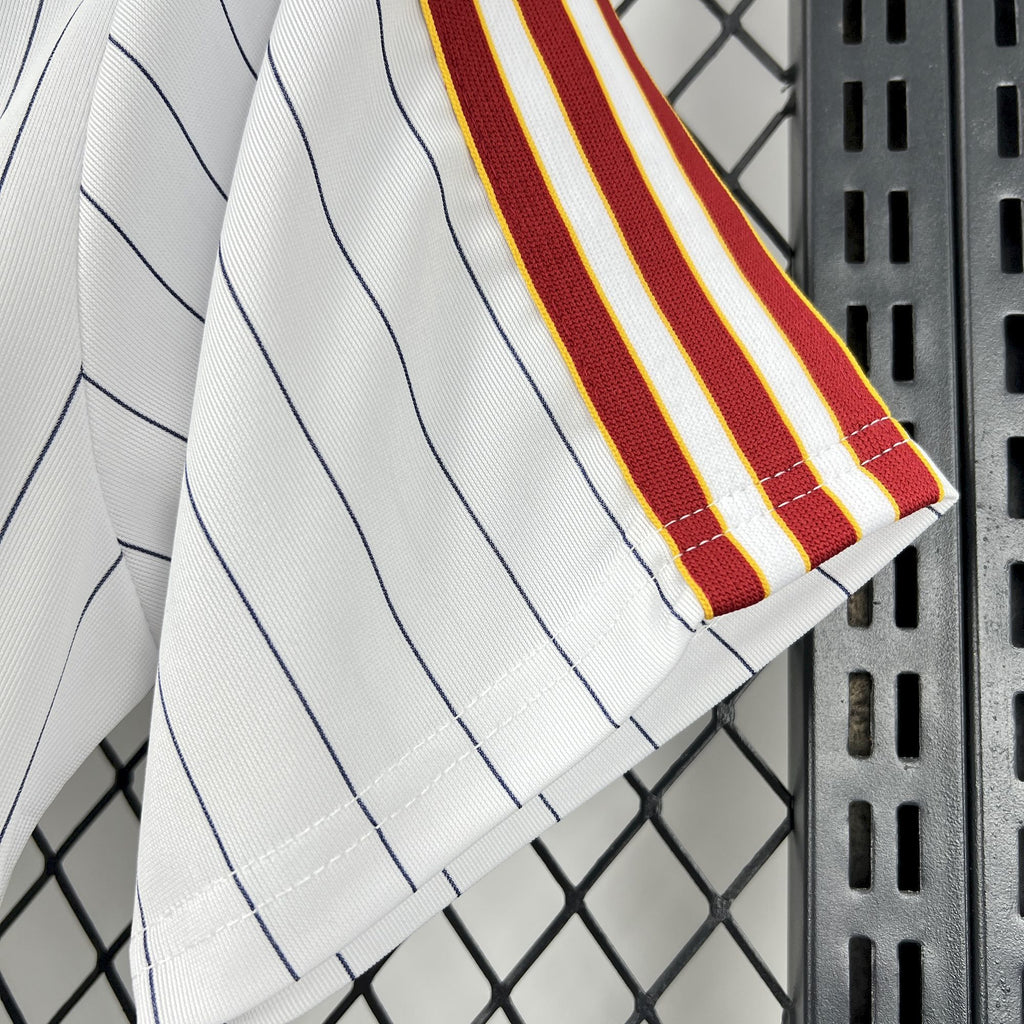 White pinstripe shirt sleeve with red-and-yellow vertical accent stripe detail