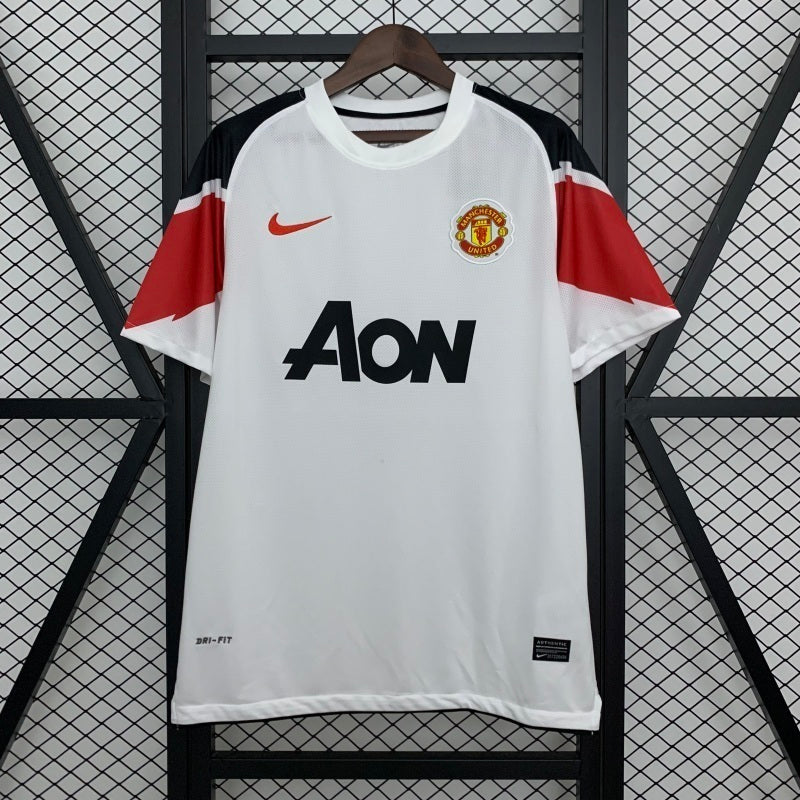 Retro white Manchester United away football jersey with red side panels and Aon sponsor