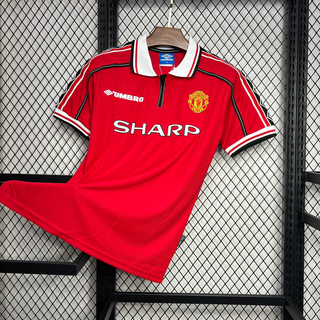 Red home soccer jersey on hanger with white collar trim, Umbro mark, and SHARP sponsor