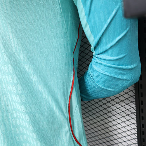 Turquoise long-sleeve jersey sleeve with red side trim and textured pattern