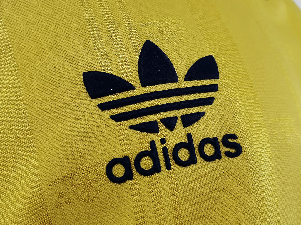 Yellow jersey close-up of adidas trefoil logo in dark navy