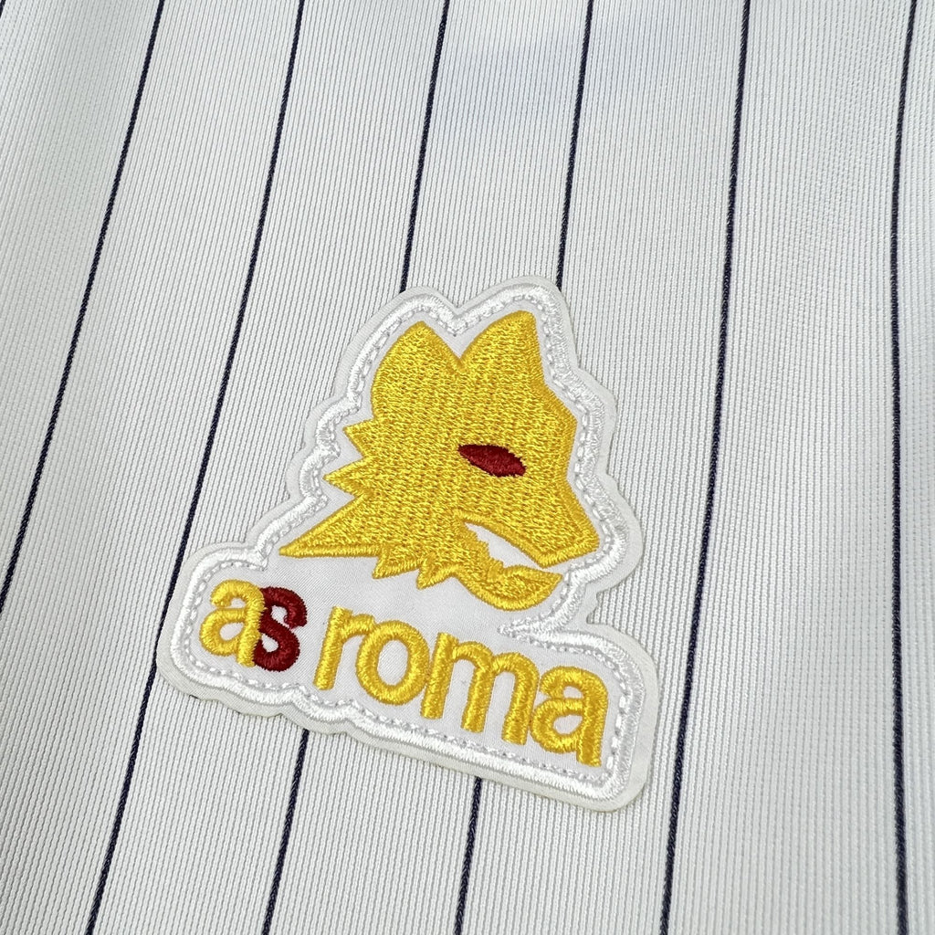 Gold lion crest and 'Roma' embroidered patch on white pinstripe soccer shirt