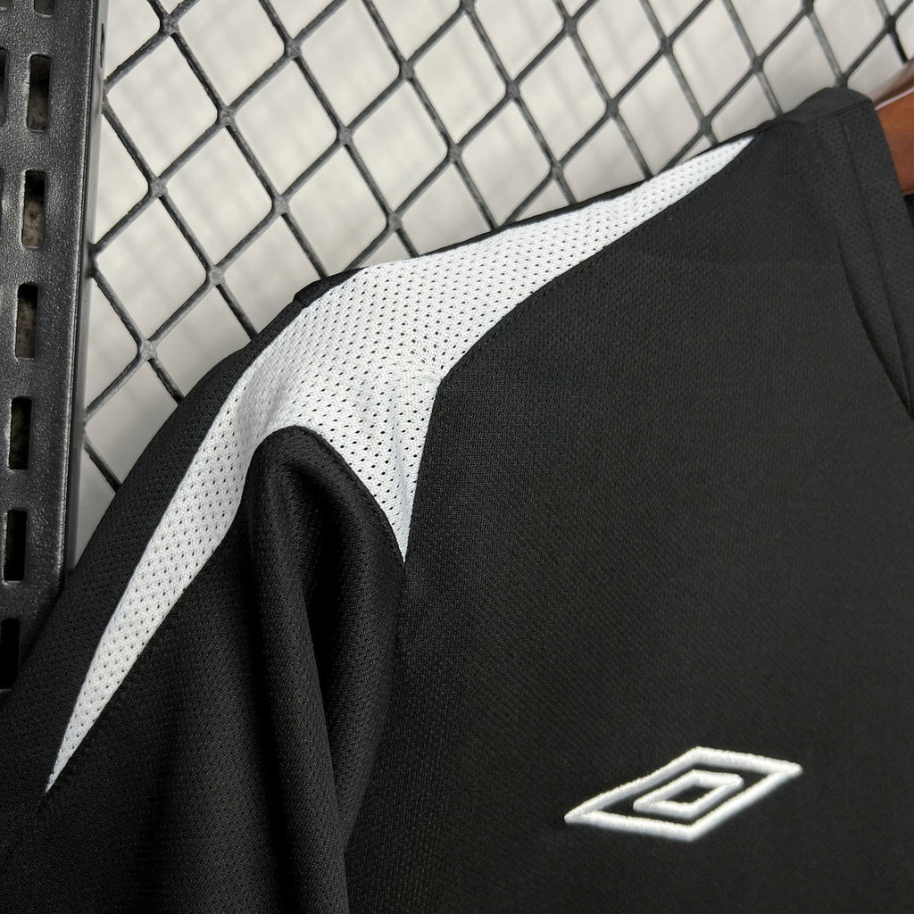 Black football jersey with white diagonal stripe and small Umbro-style logo