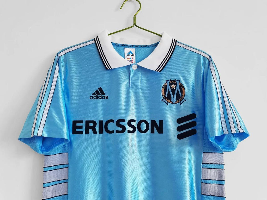 Sky blue away soccer jersey front with ERICSSON sponsor text and Marseille club badge