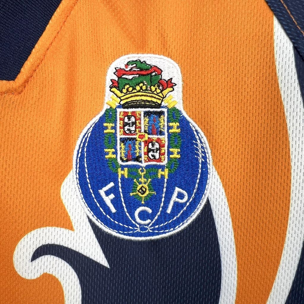 Porto away retro football jersey crest close-up on orange and navy background