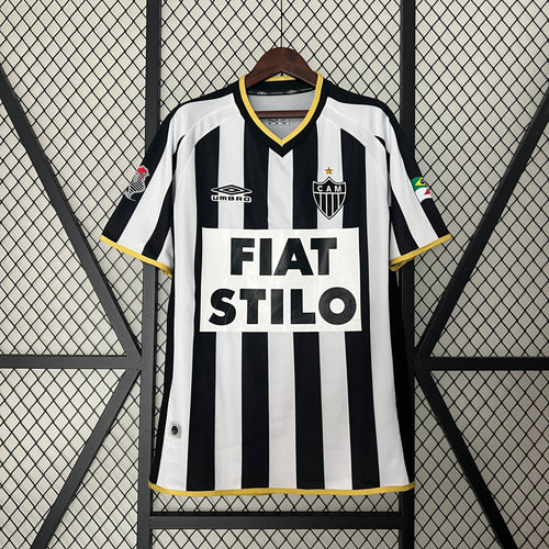 Retro black-and-white striped soccer jersey with yellow trim and bold sponsor text on front