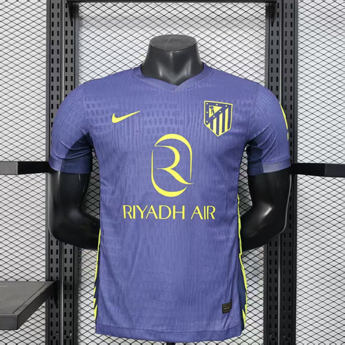 Purple soccer jersey with yellow trim, Atletico crest, Nike logo, and “RIYADH AIR” sponsor