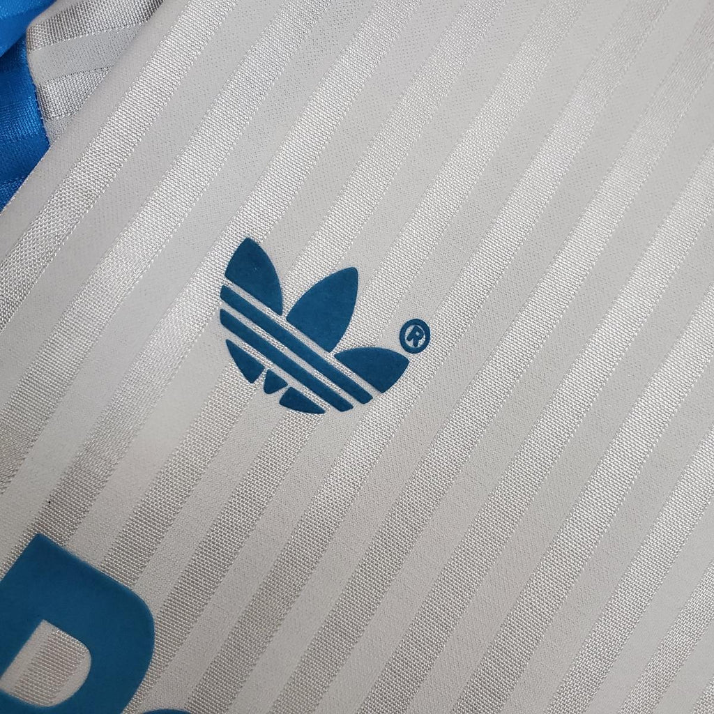 White jersey fabric with blue adidas trefoil logo on vertical stripe texture