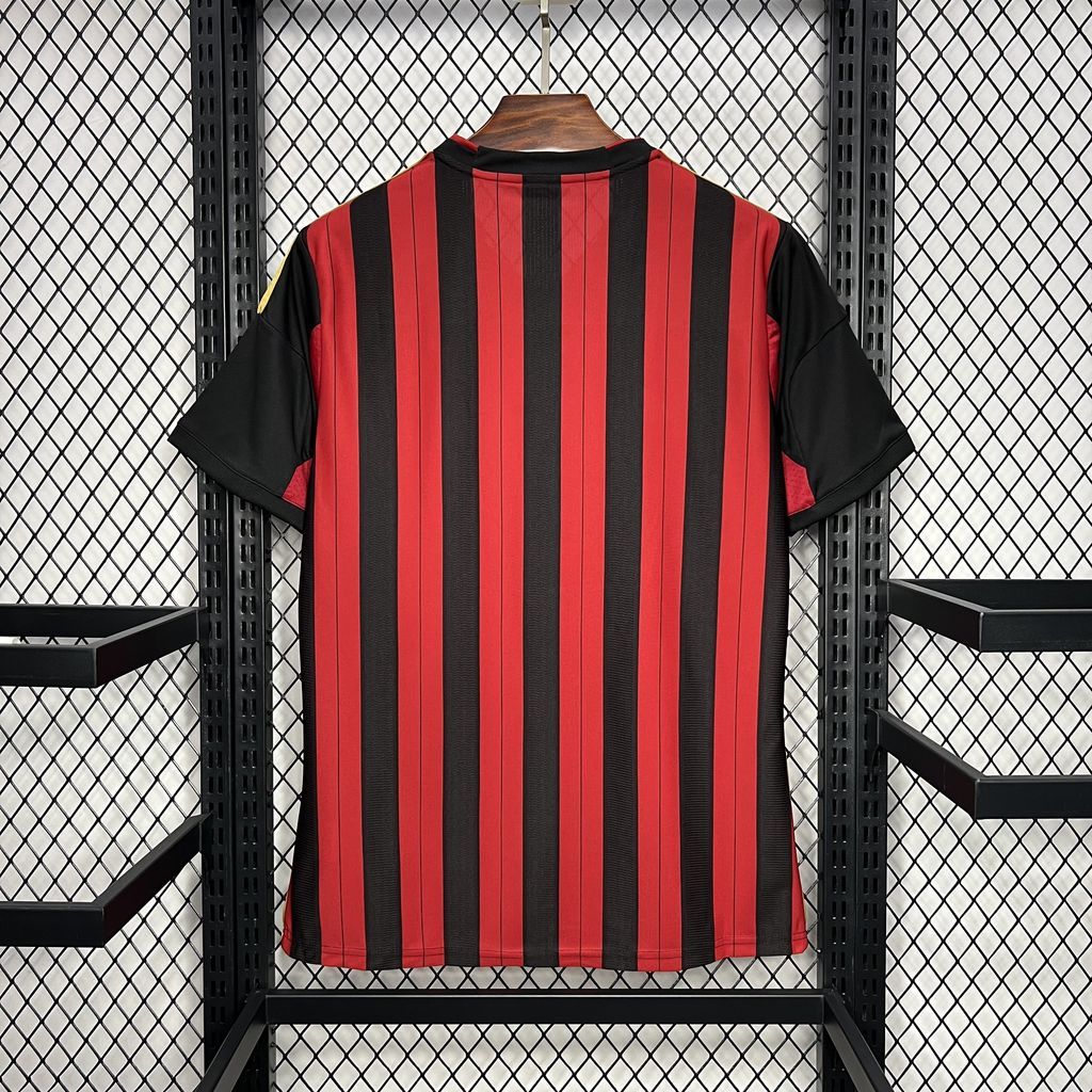 AC Milan home soccer jersey back view with red-and-black vertical stripes and yellow shoulder trim