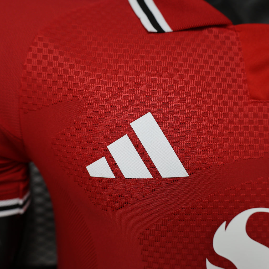 Red jersey close-up of adidas three-stripe logo on textured fabric