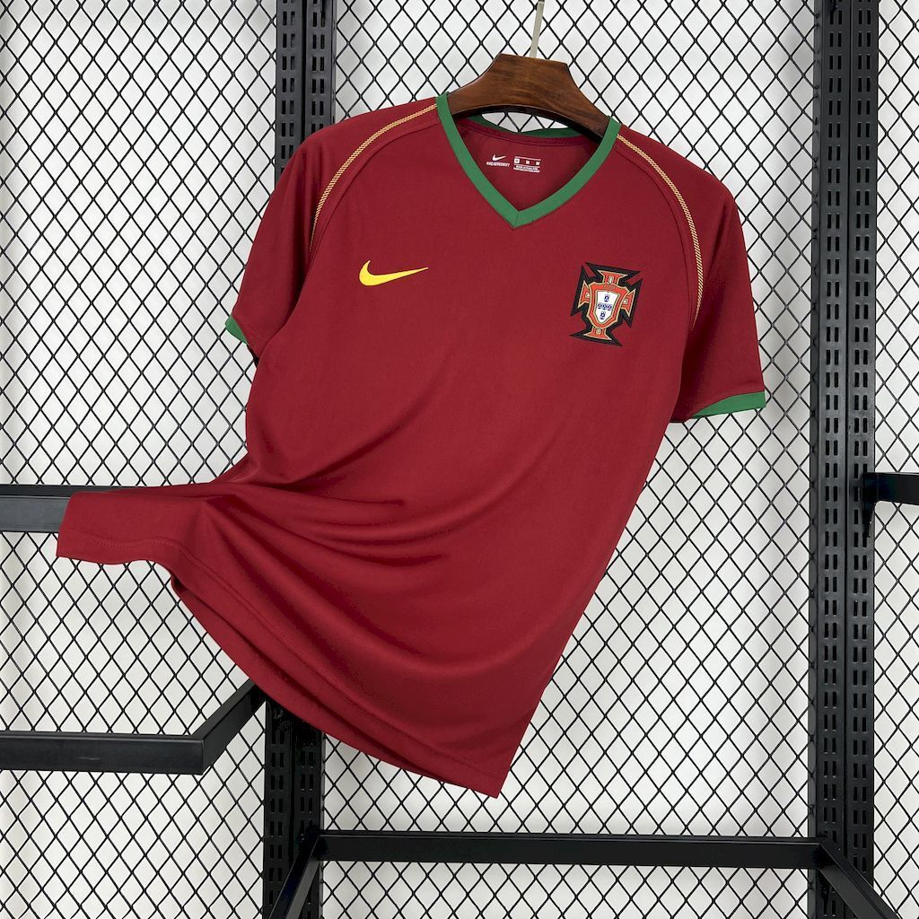 Maroon Portugal home soccer jersey with green trim, Nike swoosh, and team crest