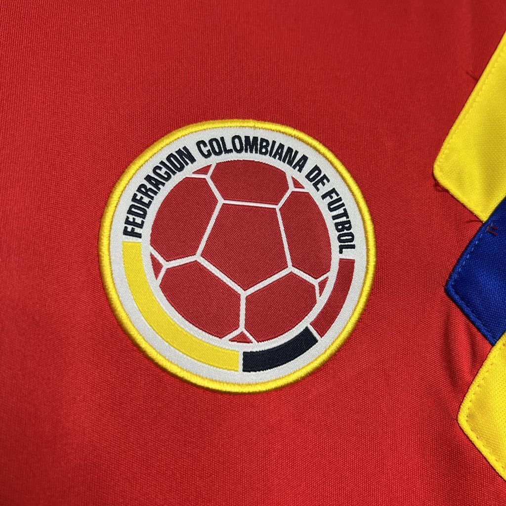 Circular Colombia football federation crest on red jersey