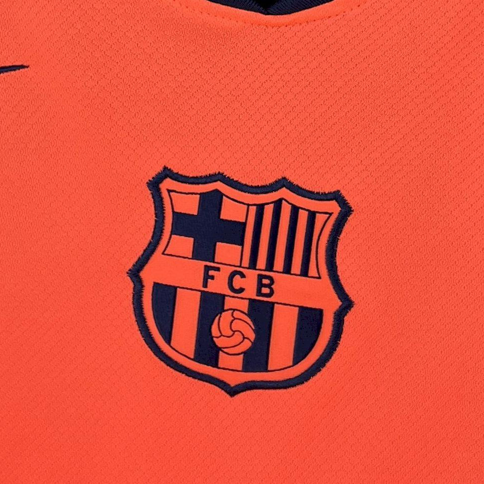 FC Barcelona shield crest on orange long-sleeve football jersey