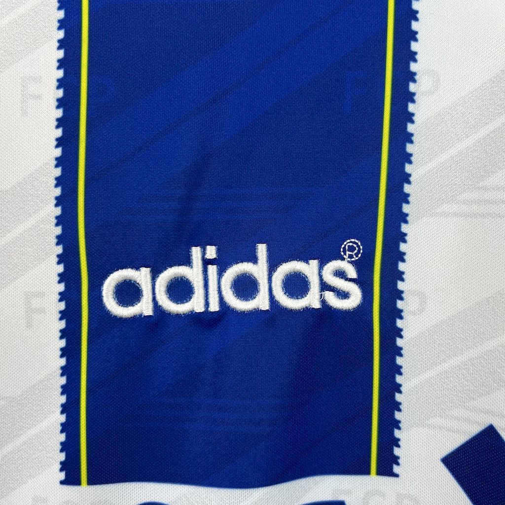 Retro home jersey close-up: adidas logo on royal blue with neon yellow trim