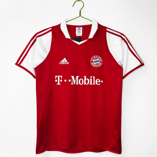 Red Bayern Munich home jersey with white sleeves, Adidas logo, T-Mobile print, crest