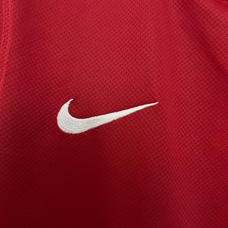 Red soccer jersey fabric with white Nike swoosh logo on chest