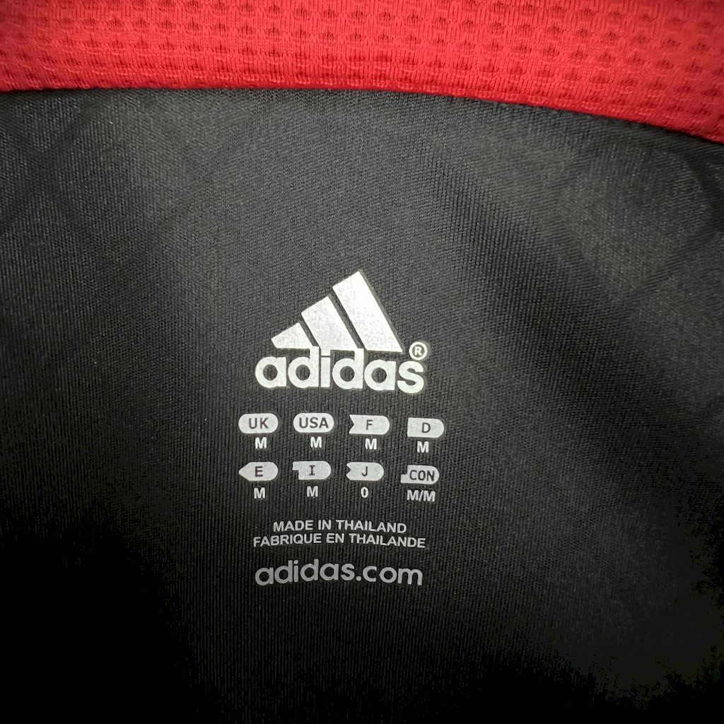 Black Adidas logo patch on jersey back with size text and Made in Thailand