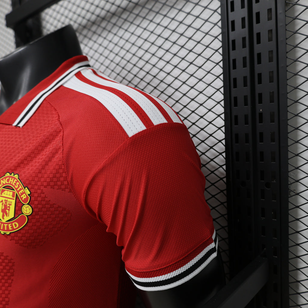Red Manchester United home shirt side view with crest and white shoulder stripes
