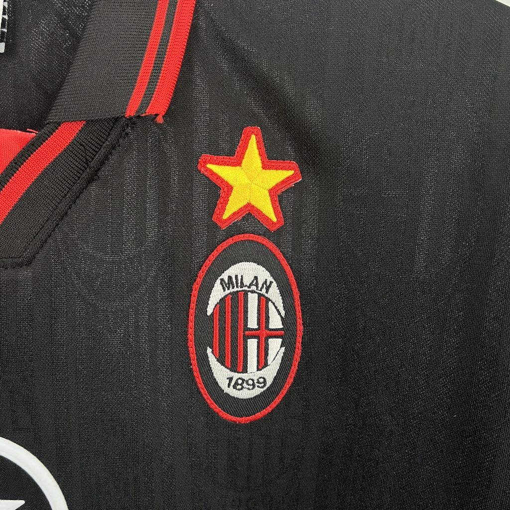 Black jersey chest detail: red star above Milan crest
