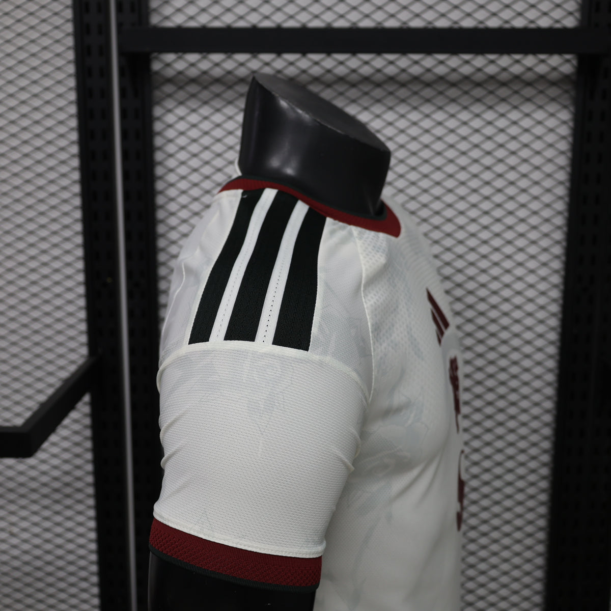 White Manchester United third player shirt sleeve with black three stripes and maroon band
