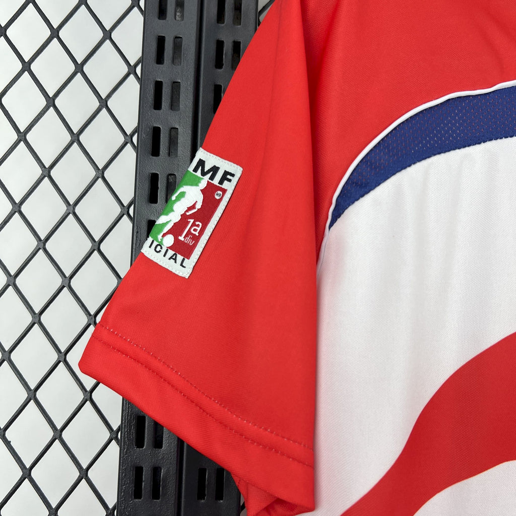 Retro soccer jersey sleeve with red cuff and sponsor patch on blue-white panel