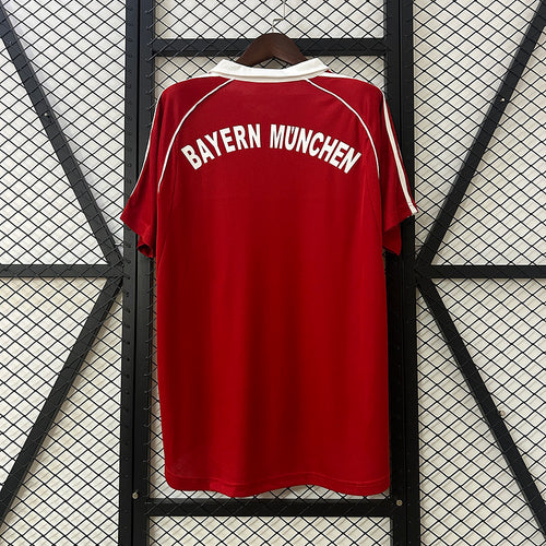 Red football jersey with white BAYERN MUNICH text across chest and white shoulder stripes