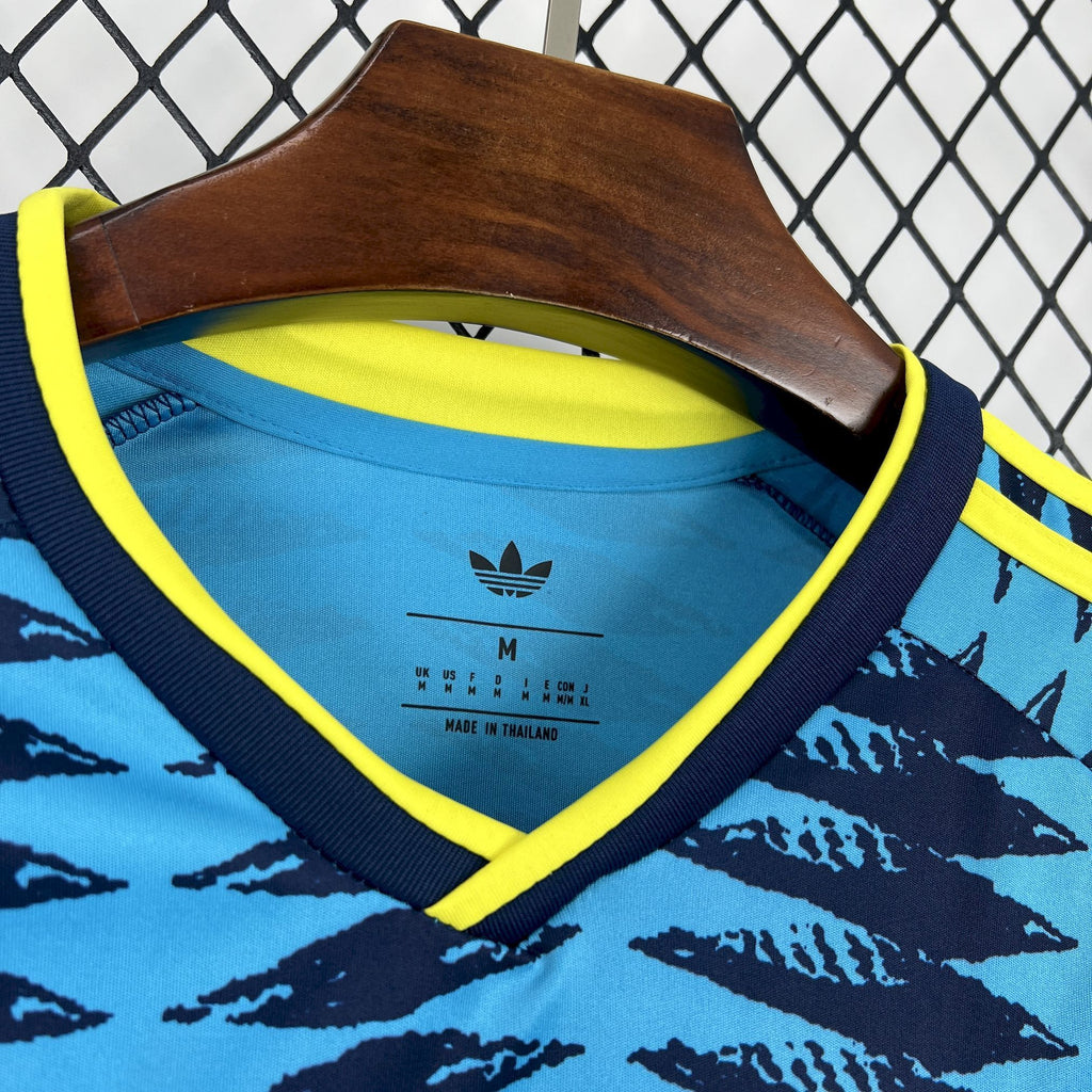 Close-up of blue V-neck jersey with yellow collar trim and Adidas-style logo