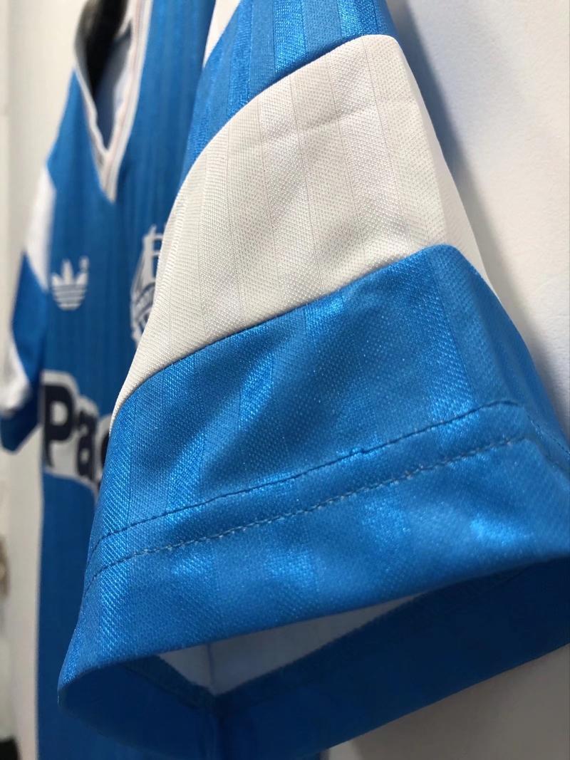 Close-up of blue jersey sleeve with white and blue fabric panels and stitched trim