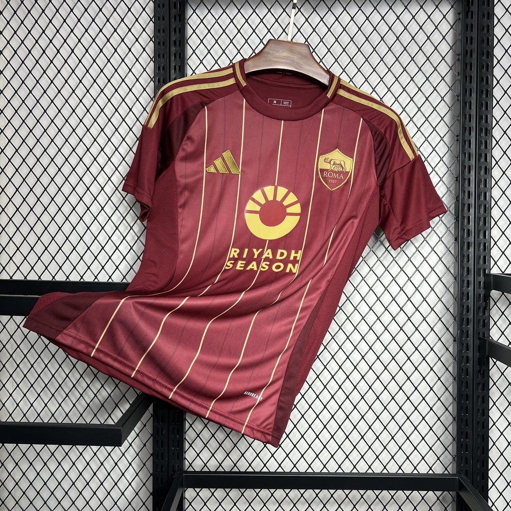 Burgundy Roma home fan jersey folded with gold stripes and Riyadh Season center logo