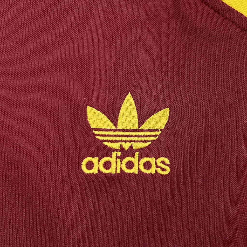 Maroon jersey with yellow adidas trefoil logo