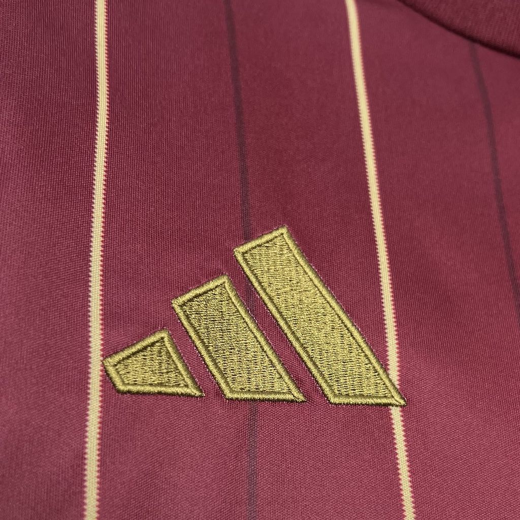 Gold adidas logo on burgundy Roma jersey with vertical gold stripe detail