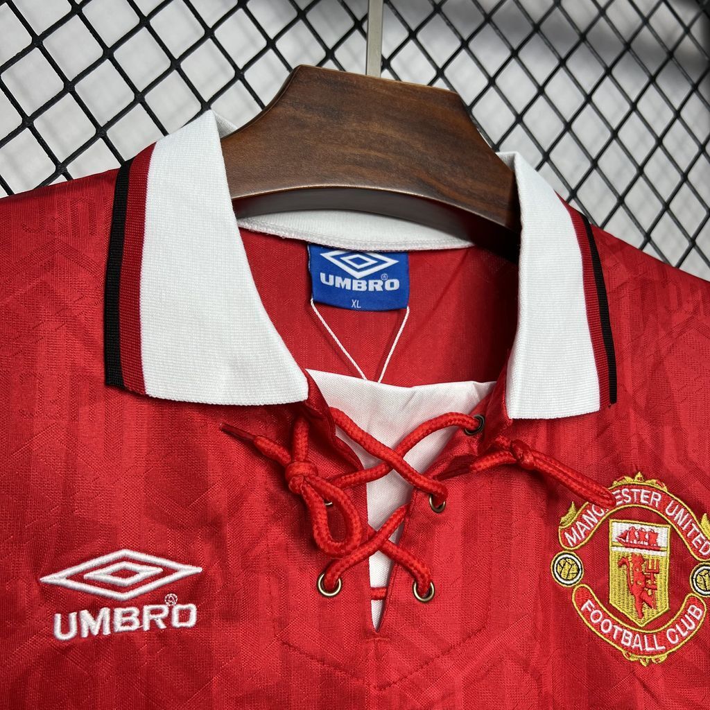 Red football jersey front close-up with Umbro logo, laced neckline, and club crest