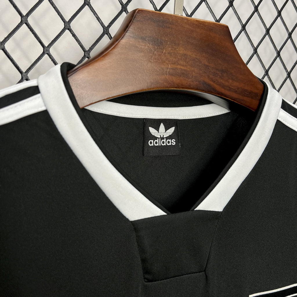 Black soccer jersey collar with white adidas logo patch and V-neck trim
