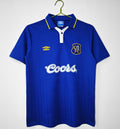 Blue Chelsea-style home football jersey with yellow collar trim and Coors logo