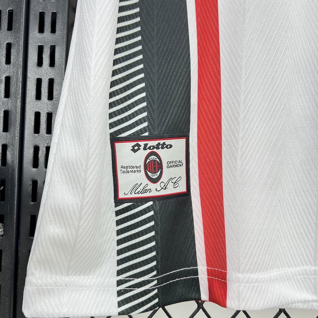 Sleeve detail with black-and-white stripes, red vertical panel, and Lotto branding patch