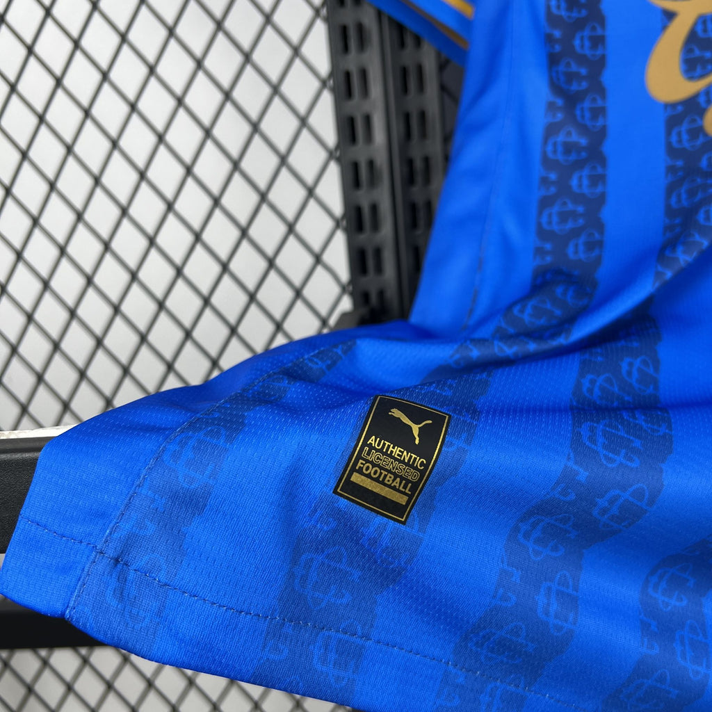 Blue soccer jersey sleeve with black 'Authentic Football' label and gold trim