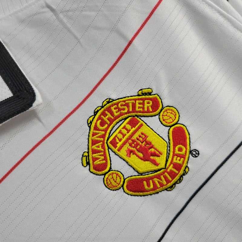 White football shirt fabric with embroidered club crest and red trim stripes