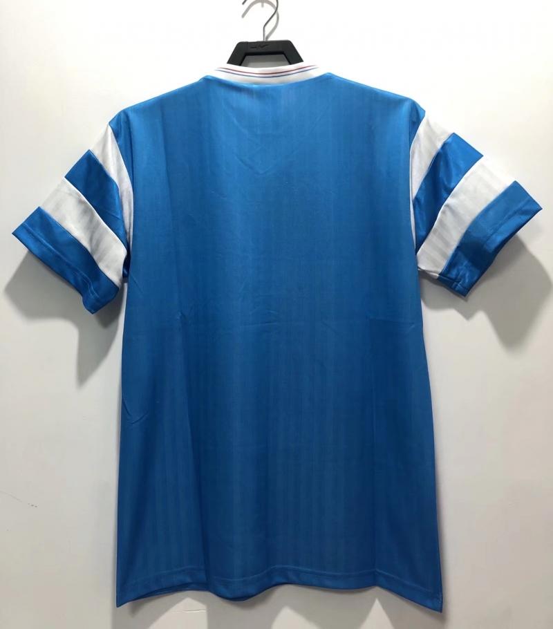 Blue back of retro soccer jersey with white striped sleeves on a hanger