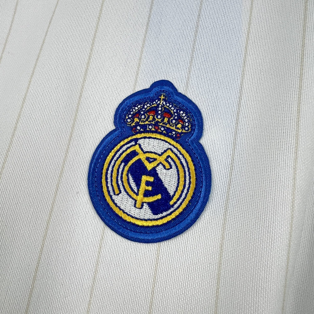 Real Madrid crest patch on white pinstriped jersey fabric